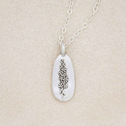 sterling silver July birth flower necklace, on beige background