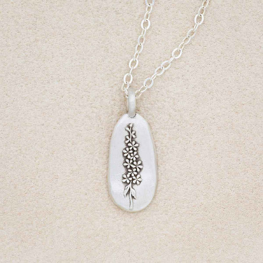 sterling silver July birth flower necklace, on beige background