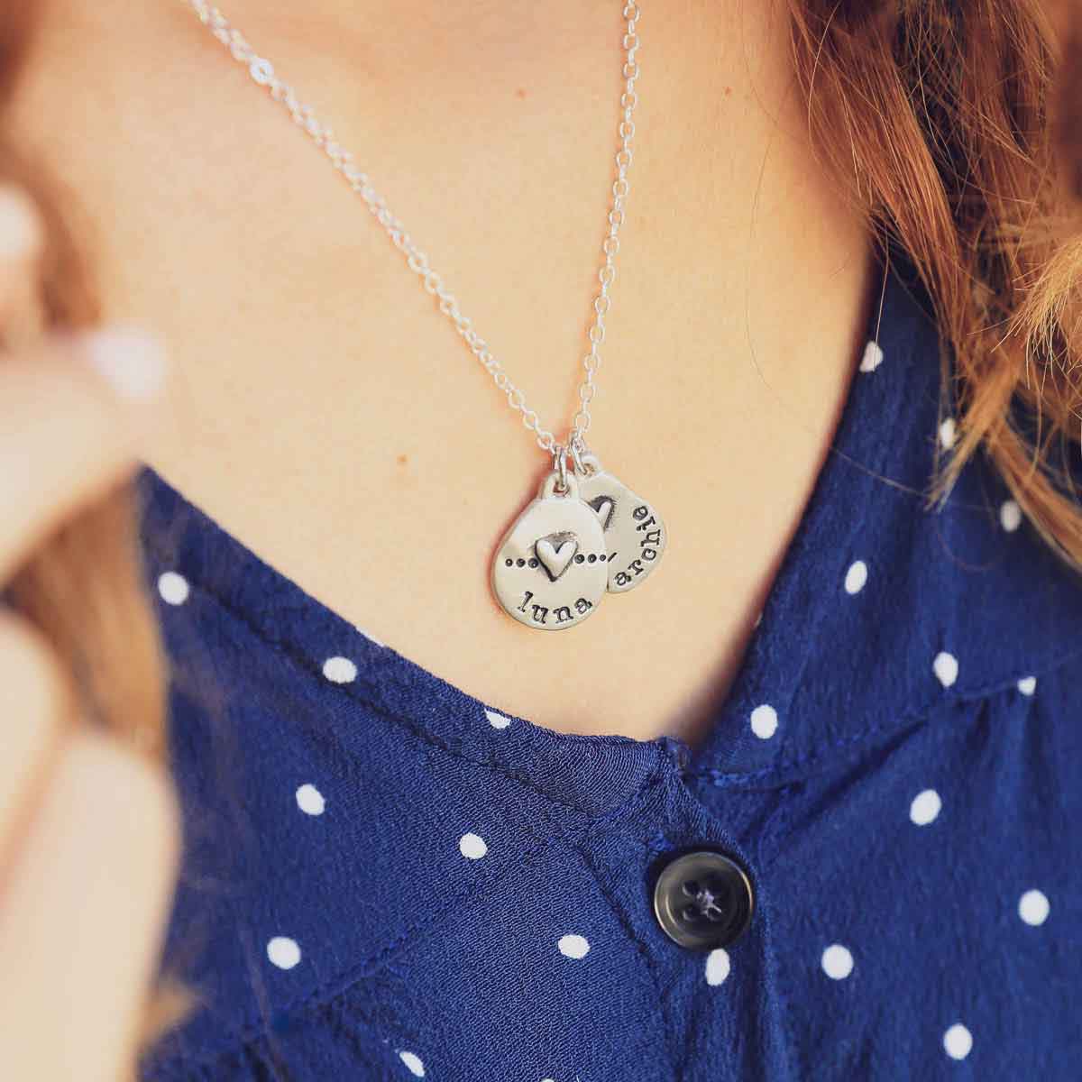 close up of girl in polka dot shirt wearing sterling silver jumble of love necklace