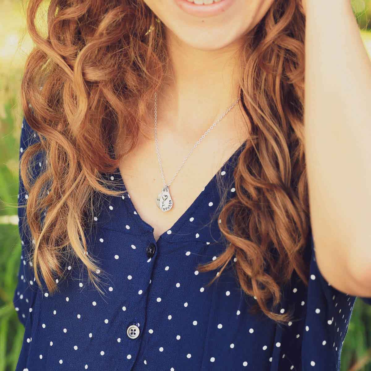 close up of girl in polka dot shirt wearing sterling silver jumble of love necklace