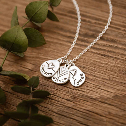 Woman holding a Personalized jumble of love necklace sterling silver in a lisa leonard box