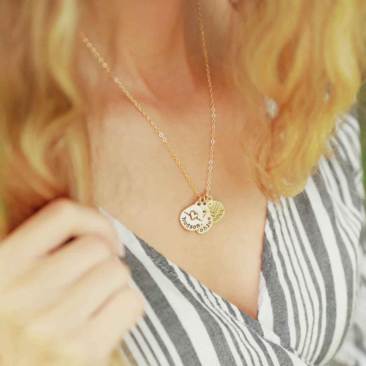 woman wearing her handcrafted 14k yellow gold personalized jumble of love necklace with a gold charm