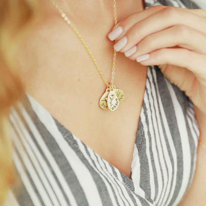 woman wearing her handcrafted 14k yellow gold personalized jumble of love necklace with a gold charm