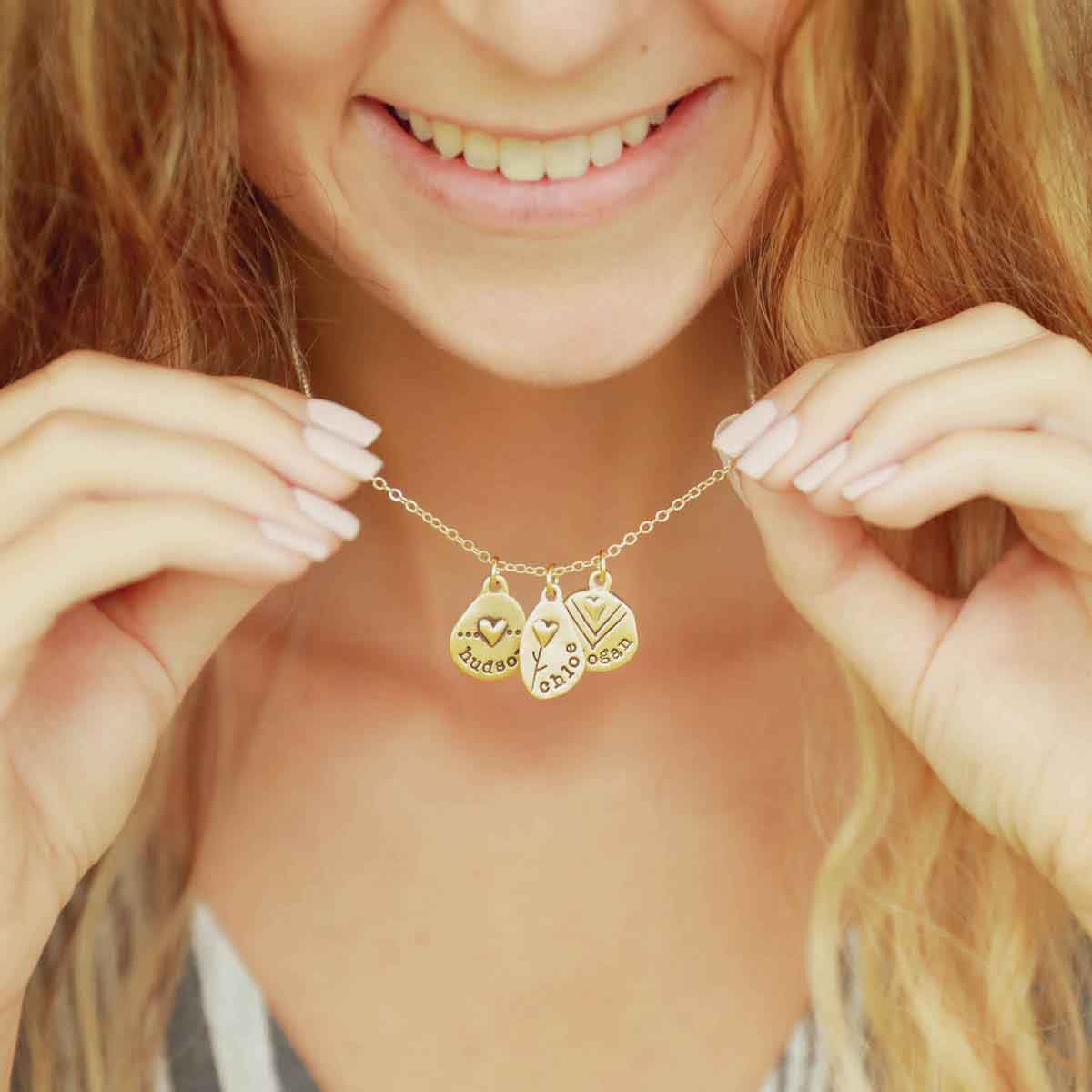 woman wearing her handcrafted 14k yellow gold personalized jumble of love necklace with a gold charm