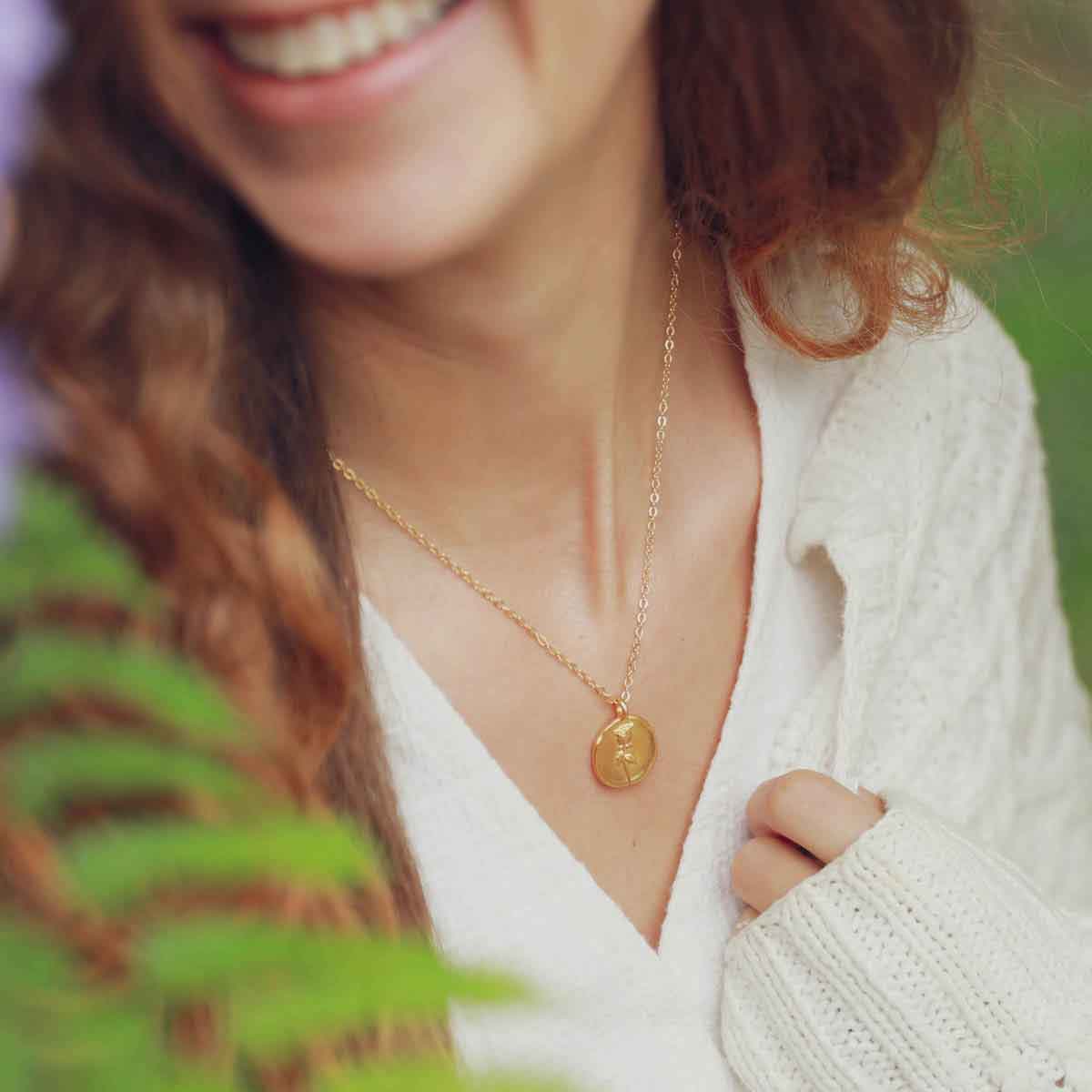 girl wearing a gold plated June birth flower necklace with an 18" gold filled link chain