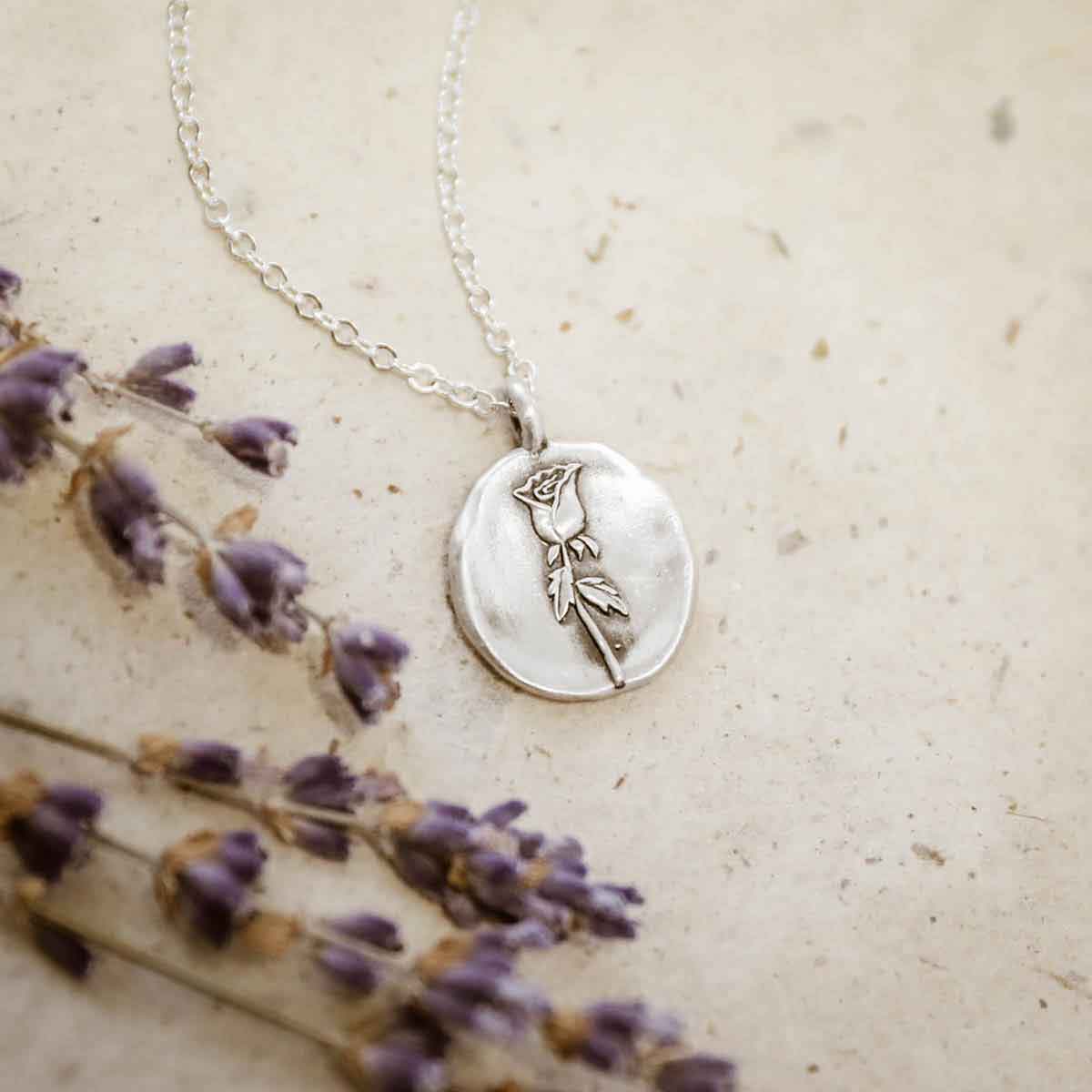 girl holding a sterling silver June birth flower necklace