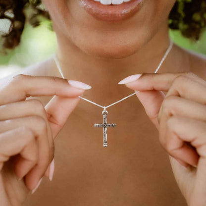 woman holding a sterling silver Justified Cross Necklace