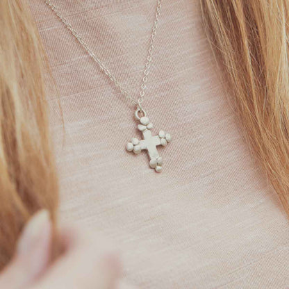 Girl wearing her Known and loved cross necklace handcrafted in sterling silver with the cross charm hanging from choice of chain