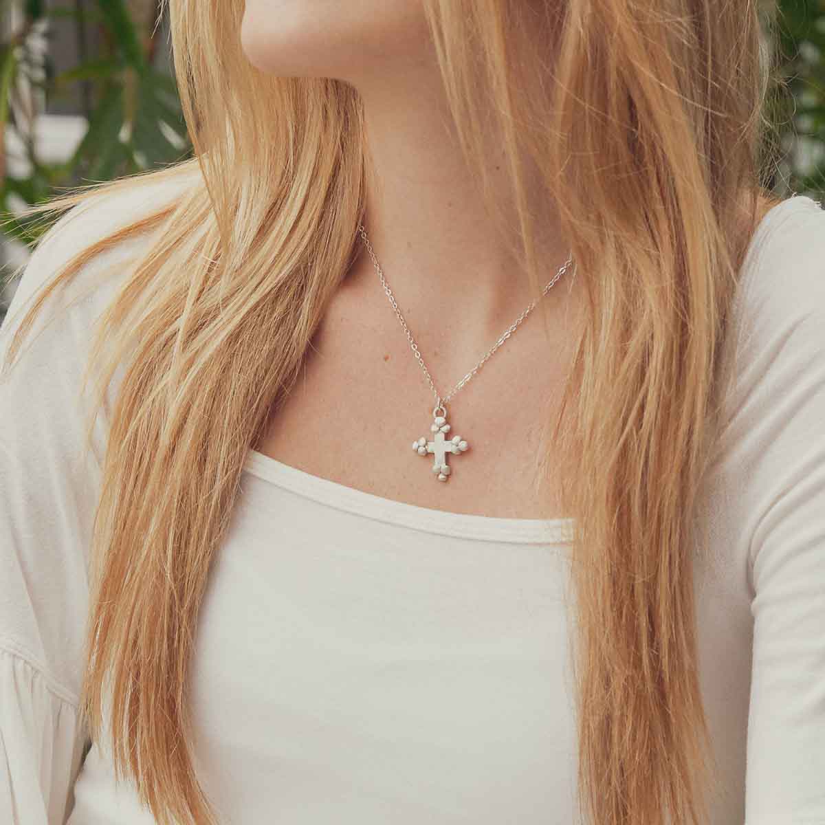 Girl wearing her Known and loved cross necklace handcrafted in sterling silver with the cross charm hanging from choice of chain