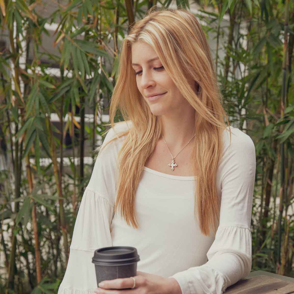 Girl wearing her Known and loved cross necklace handcrafted in sterling silver with the cross charm hanging from choice of chain