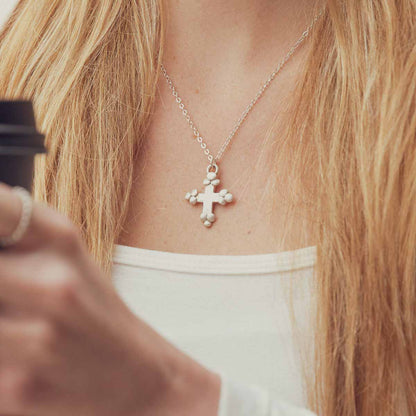 Girl wearing her Known and loved cross necklace handcrafted in sterling silver with the cross charm hanging from choice of chain