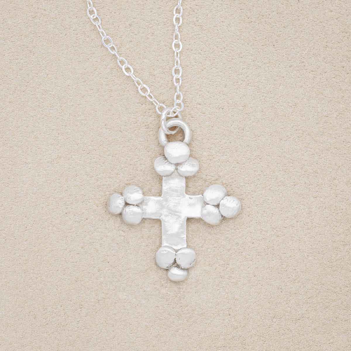 Known and loved cross necklace handcrafted in sterling silver with the cross charm hanging from choice of chain