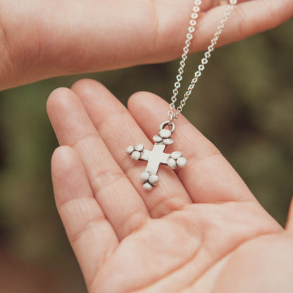 Known and loved cross necklace handcrafted in sterling silver with the cross charm hanging from choice of chain