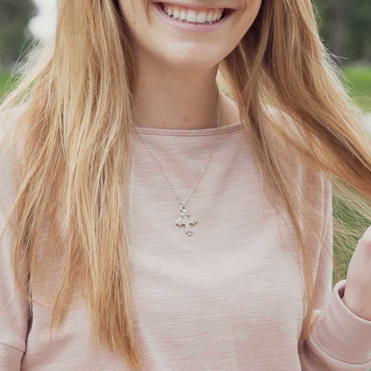 Girl wearing her Known and loved cross necklace handcrafted in sterling silver with the cross charm hanging from choice of chain