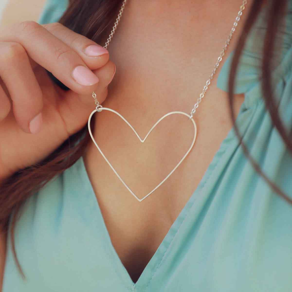 A sterling silver Large Peaceful Heart Necklace on a slate floral background