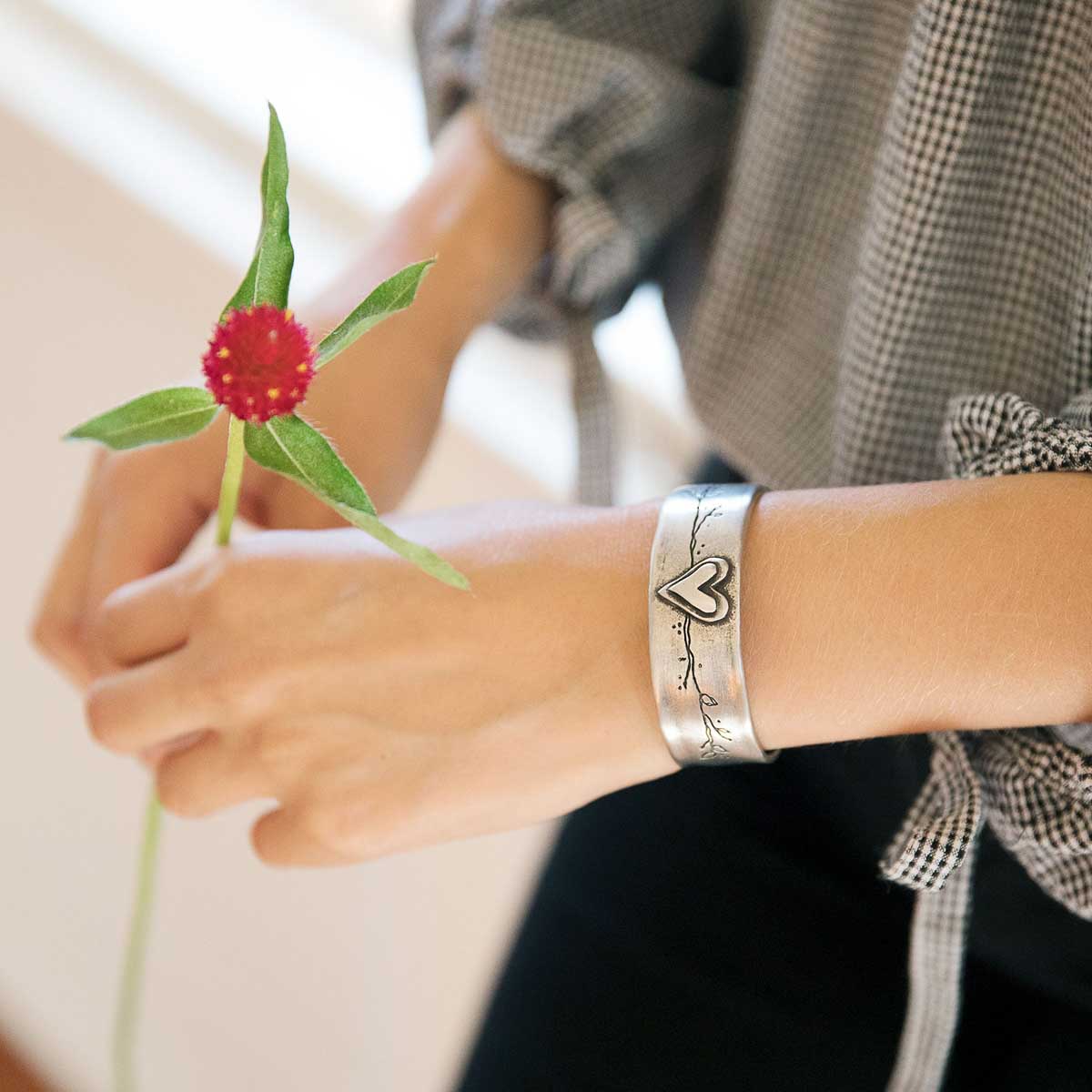 Girl with her handcrafted pewter let love grow cuff