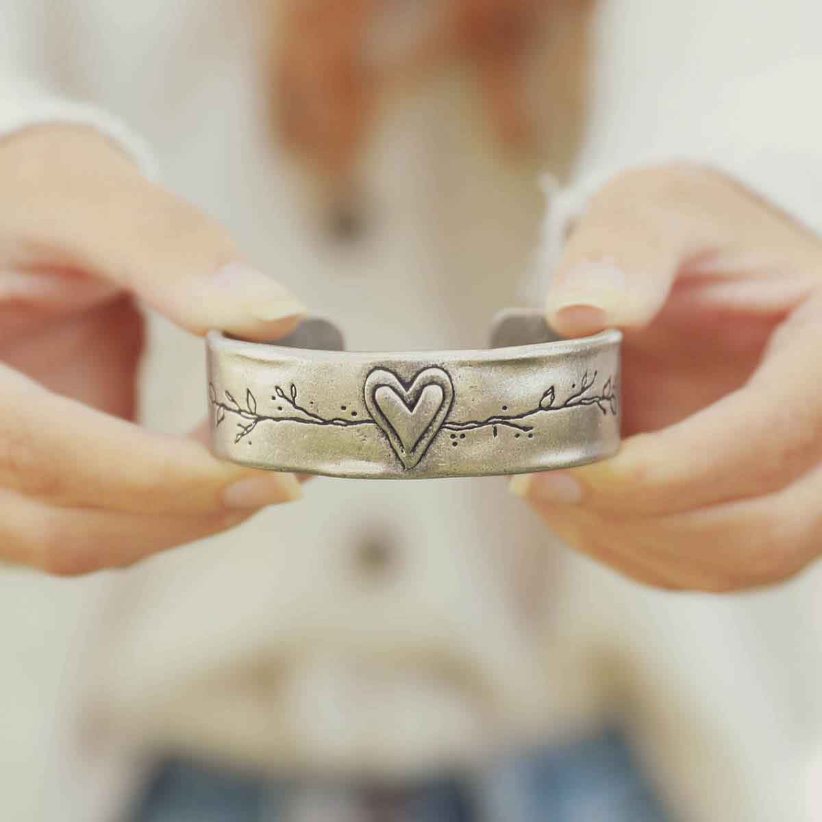 girl holding pewter let love grow cuff