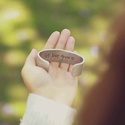 girl holding pewter let love grow cuff