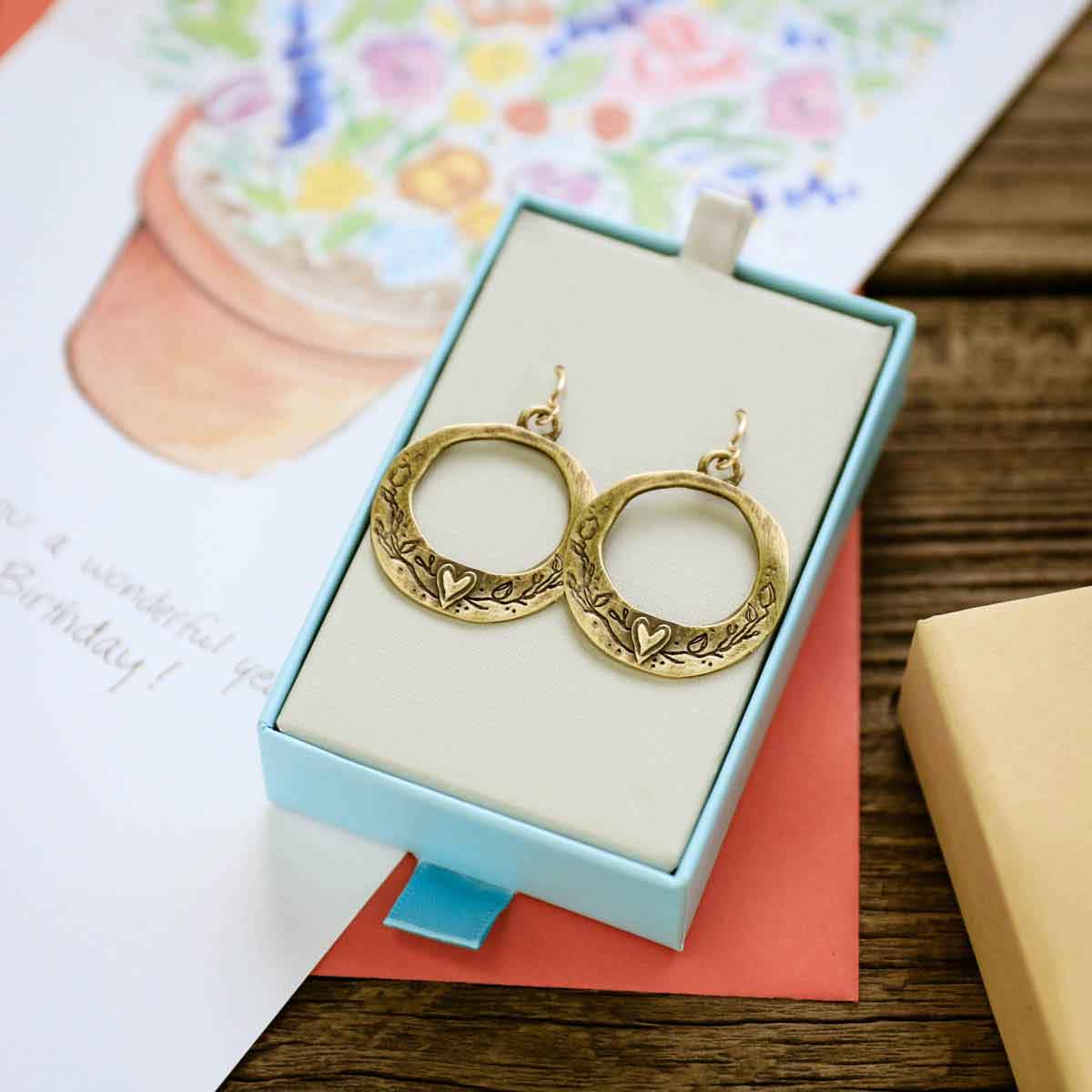 pair of let love grow hoop earrings in bronze