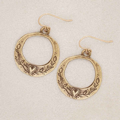 let love grow hoop earrings in gold plated, on suedge background