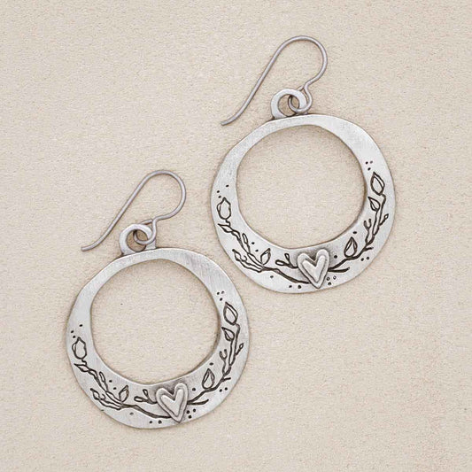 pewter let love grow hoop earrings on suede background