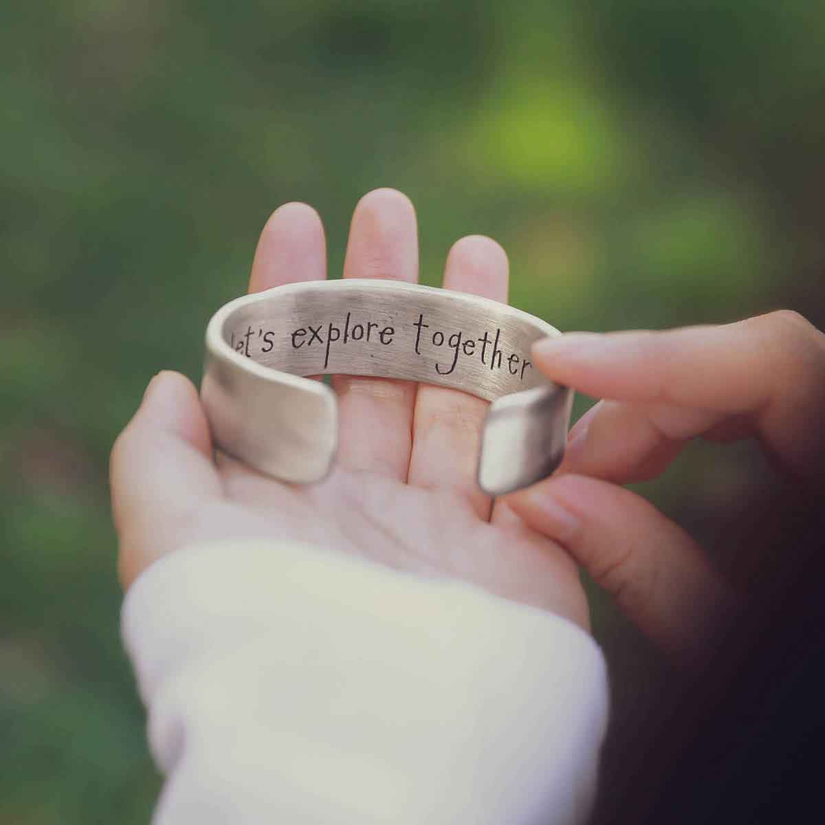 girl holding a Let's Explore Together Cuff