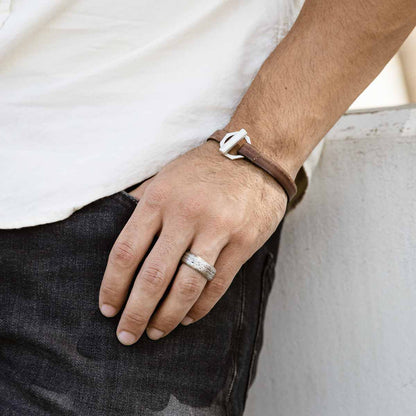 Man wearing Life Forever bracelet handcrafted in water buffalo brown leather and a sterling silver toggle closure along with other sterling silver jewelry