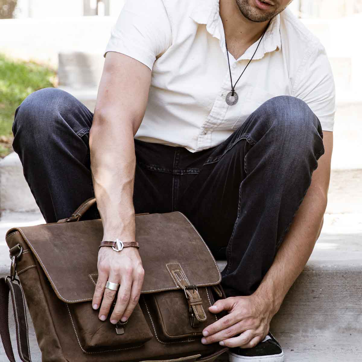 Man wearing Life Forever bracelet handcrafted in water buffalo brown leather and a sterling silver toggle closure with other leather products