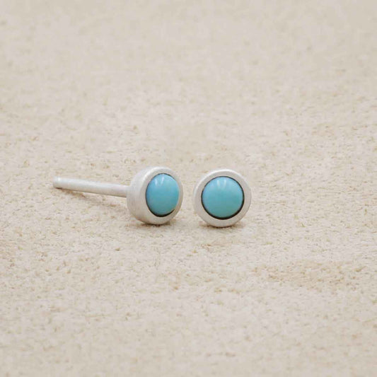 sterling silver Lighthearted Turquoise Stud Earrings on beige background