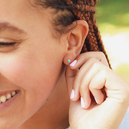 girl wearing lighthearted turquoise stud earrings