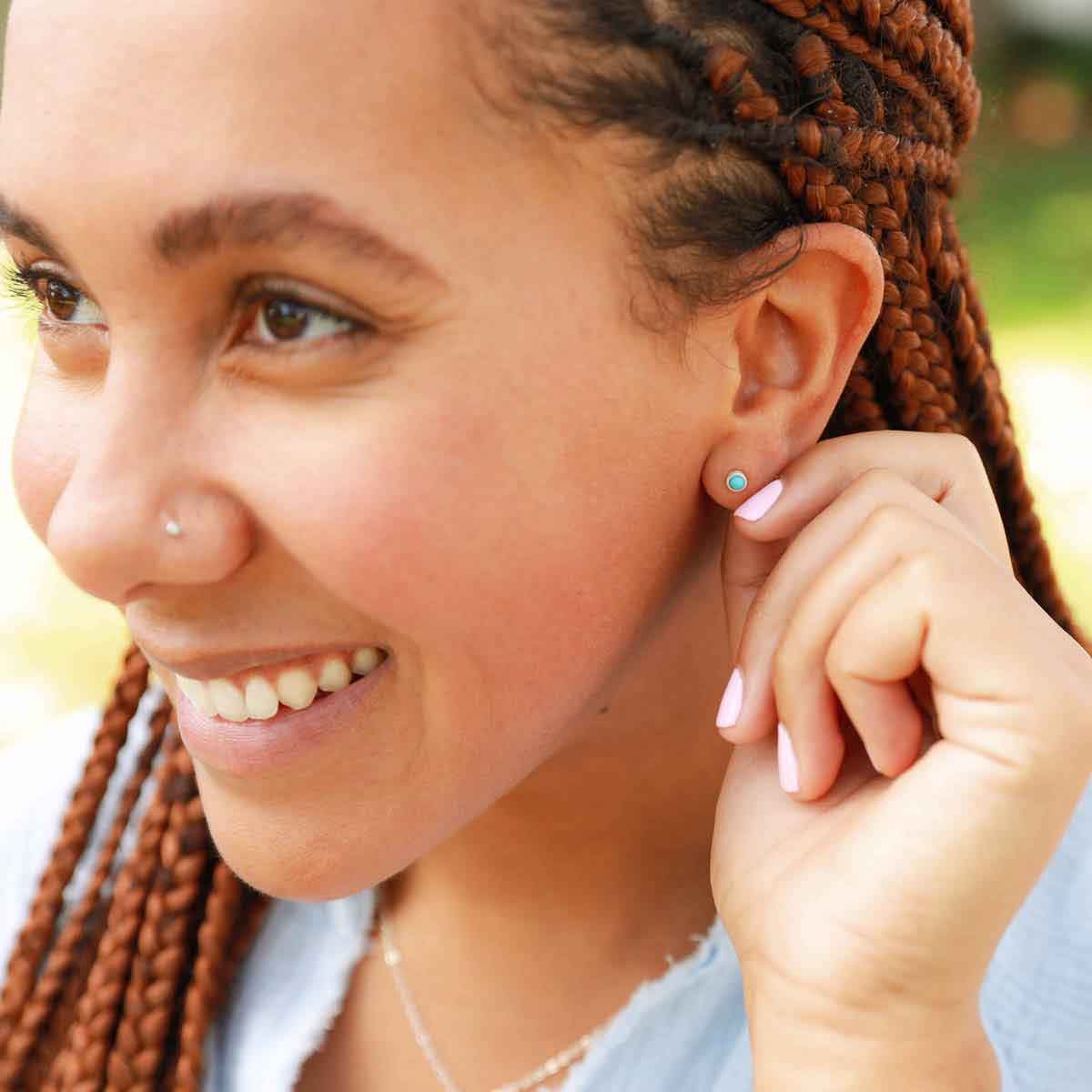 girl wearing lighthearted turquoise stud earrings