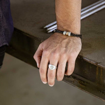 Man wearing Limitless Leather bracelet handcrafted with black bolo leather cord and choice of personalized sterling silver and bronze limitless rings