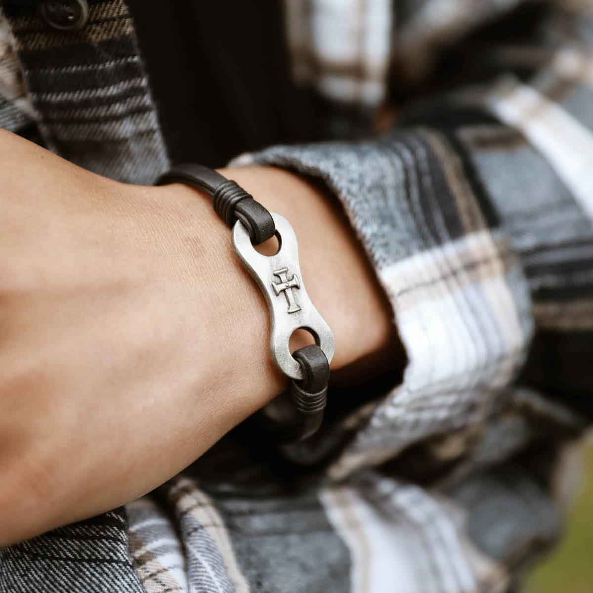 man wearing linked together cross bracelet with girlfriend in front of christmas tree