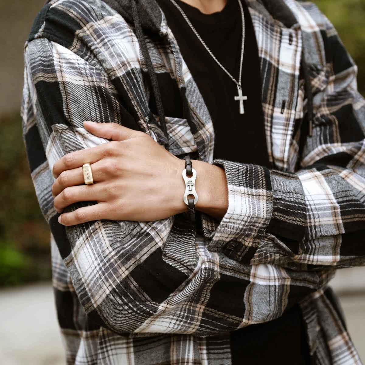 man holding linked together cross bracelet out of gift box