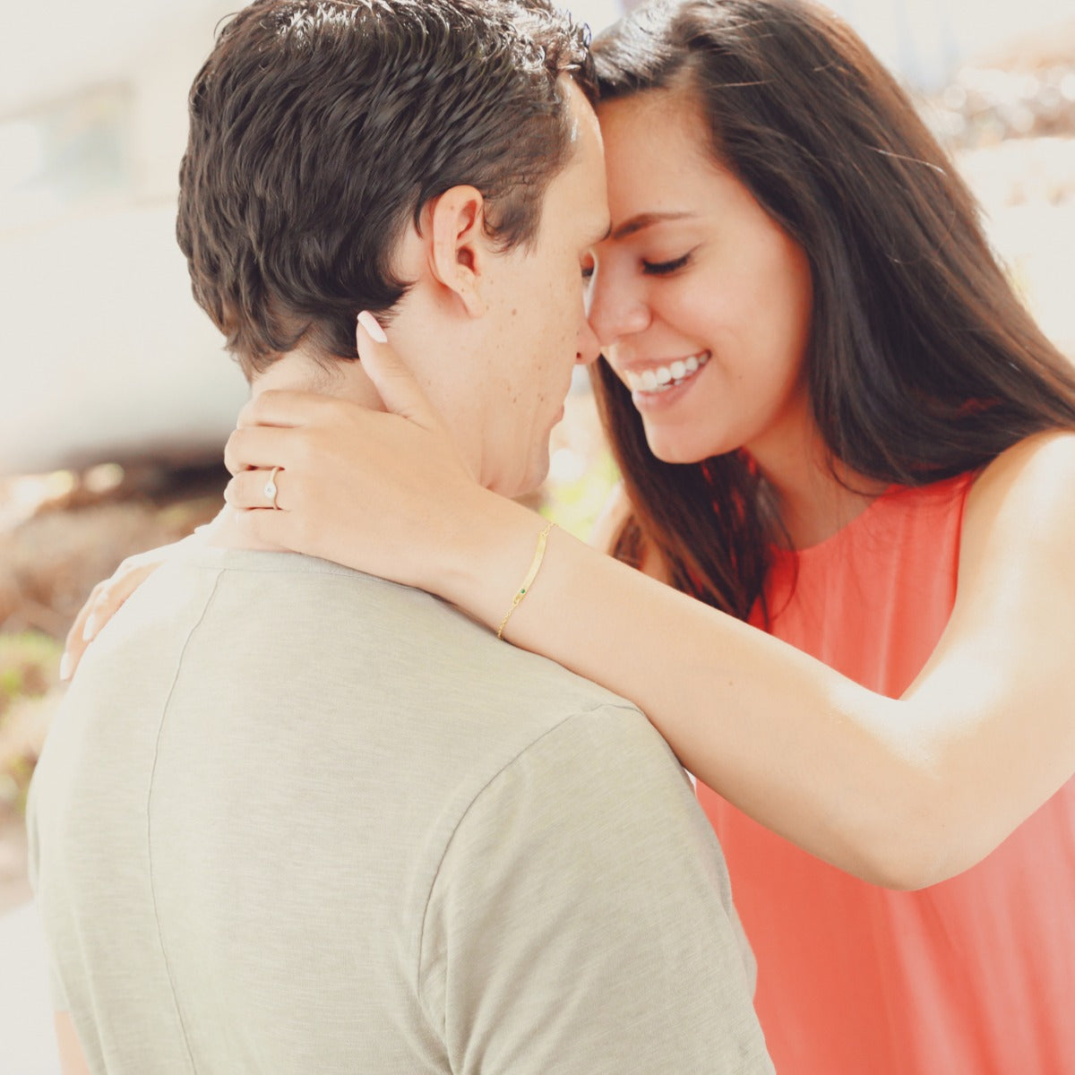 Couple hugging with woman wearing her handcrafted 14k cross bar birthstone bracelet