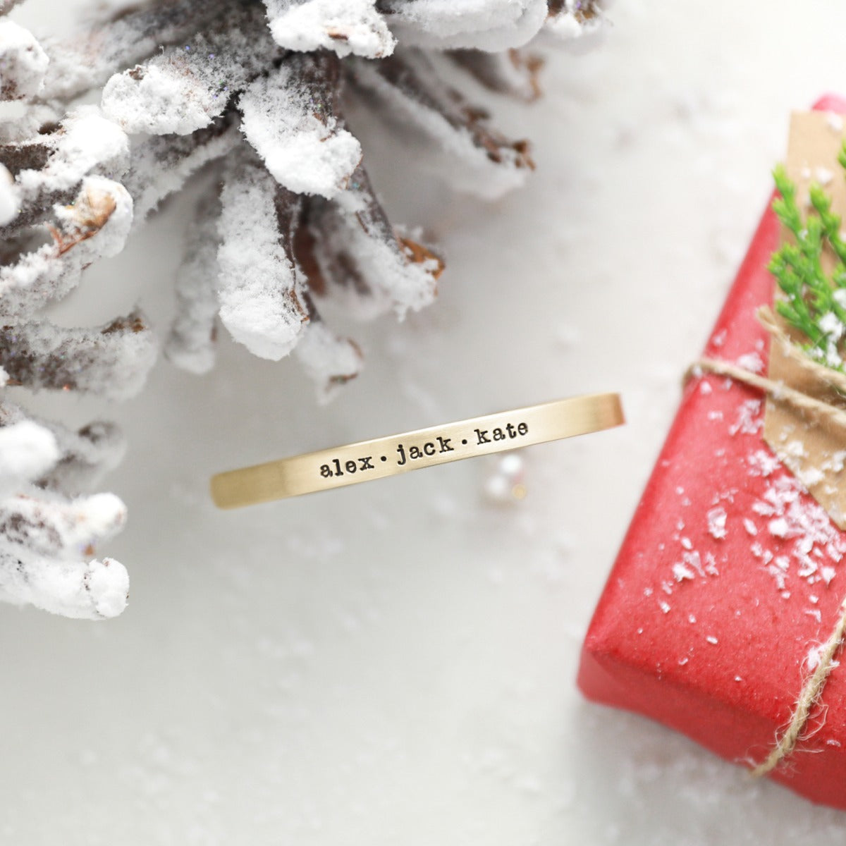 personalized thin gold cuff on snowy white background