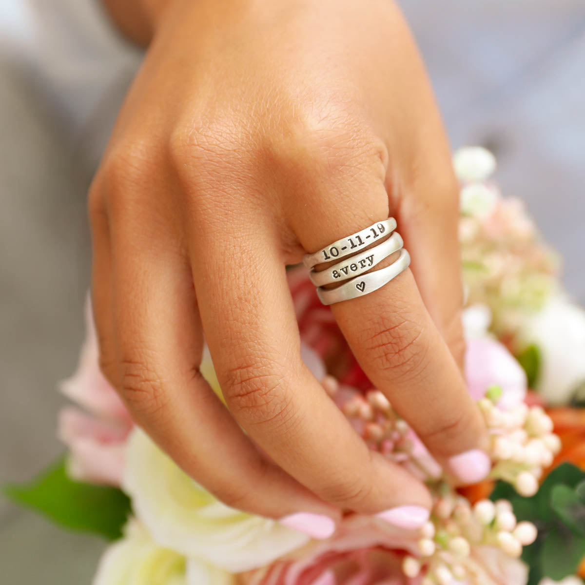 girl wearing personalized sterling silver stackable name ring trio 