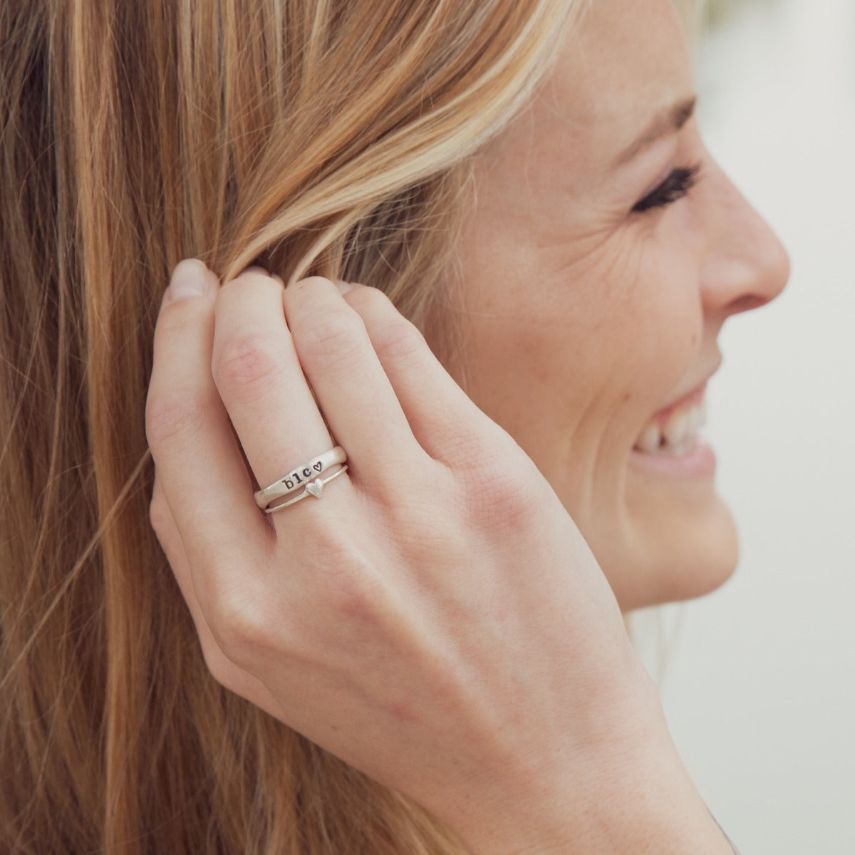 girl wearing a sterling silver sweet love ring - one heart  with a personalized stackable name ring