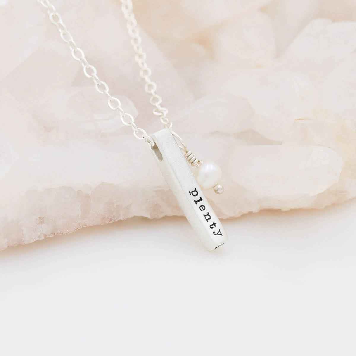 sterling silver word of the year necklace laying on marble