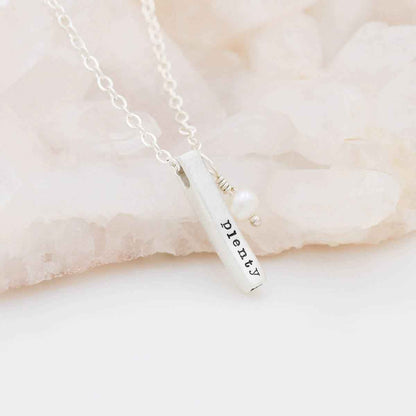 sterling silver word of the year necklace laying on marble