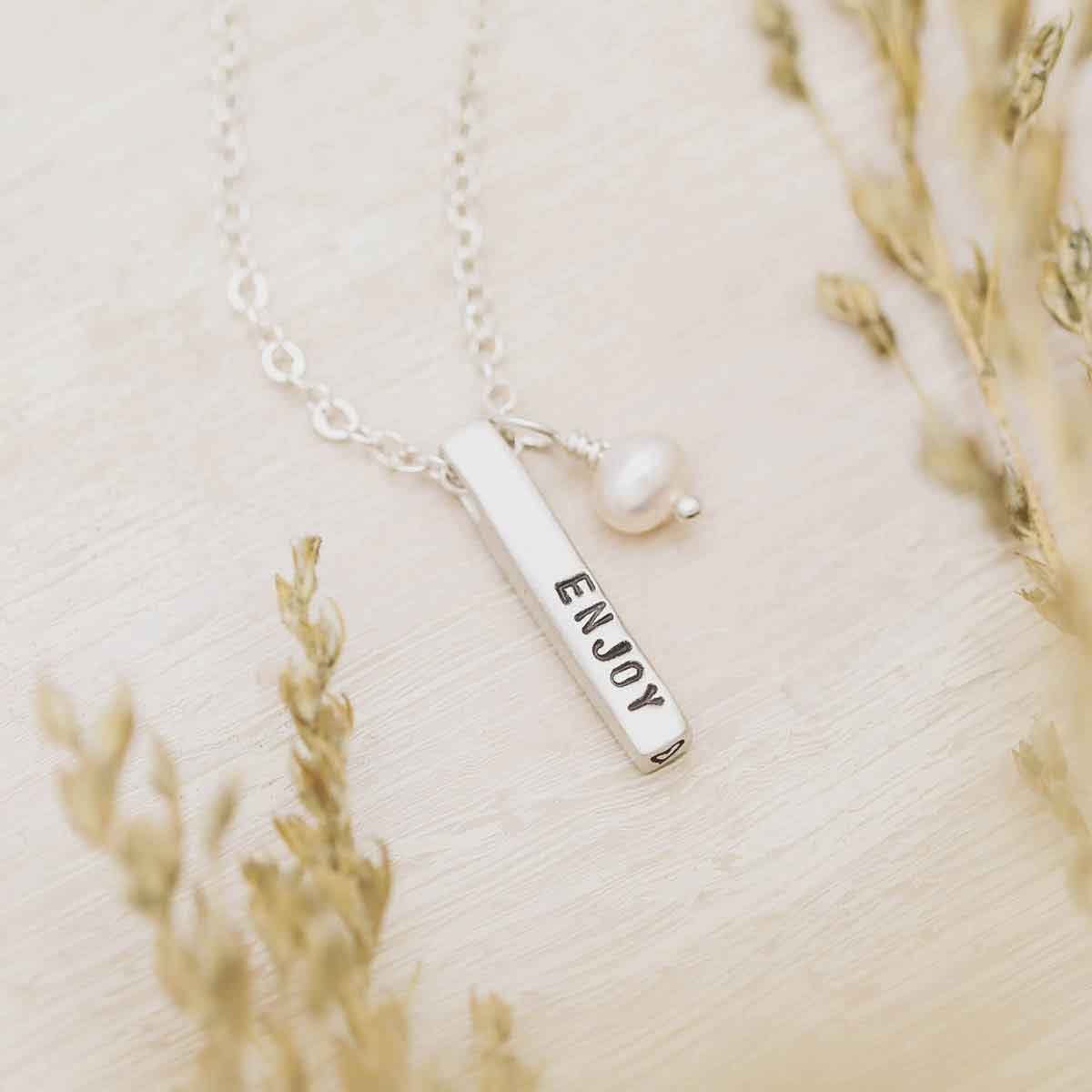 girl holding word of the year necklace in lisa leonard necklace box