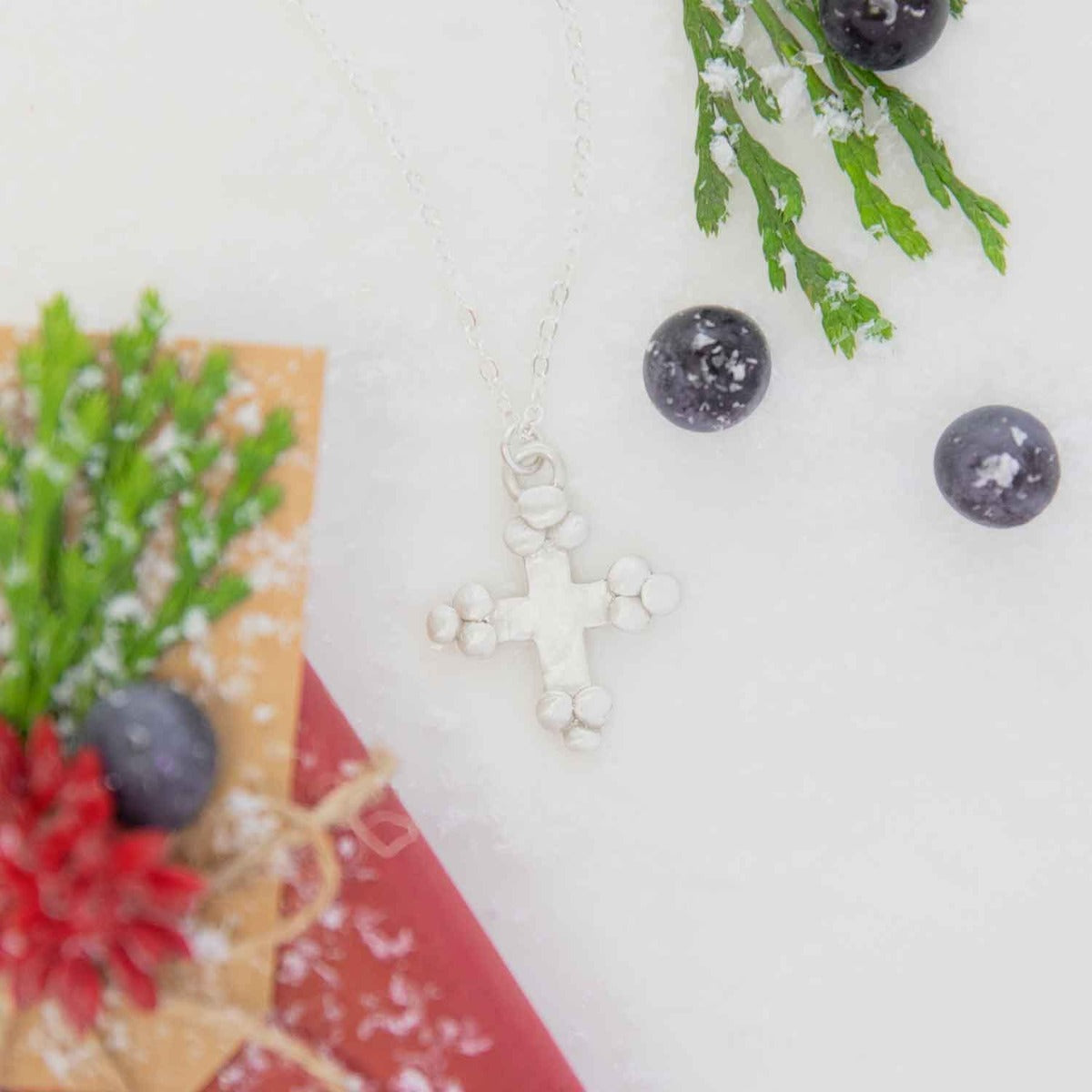 Known and loved cross necklace handcrafted in sterling silver with the cross charm hanging from choice of chain