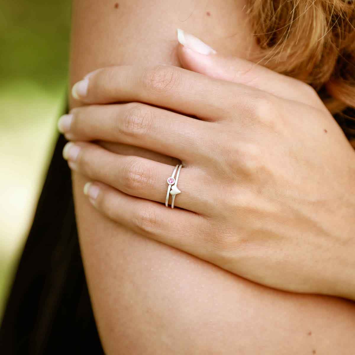 Girl wearing love and loss ring pair hand-molded and cast in sterling silver with genuine stones