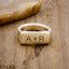 a 14k yellow gold Make Your Mark Signet Ring, personalized with monogram, on wood background