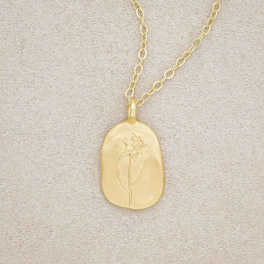 gold plated March birth flower necklace with an 18" gold filled link chain, on beige background