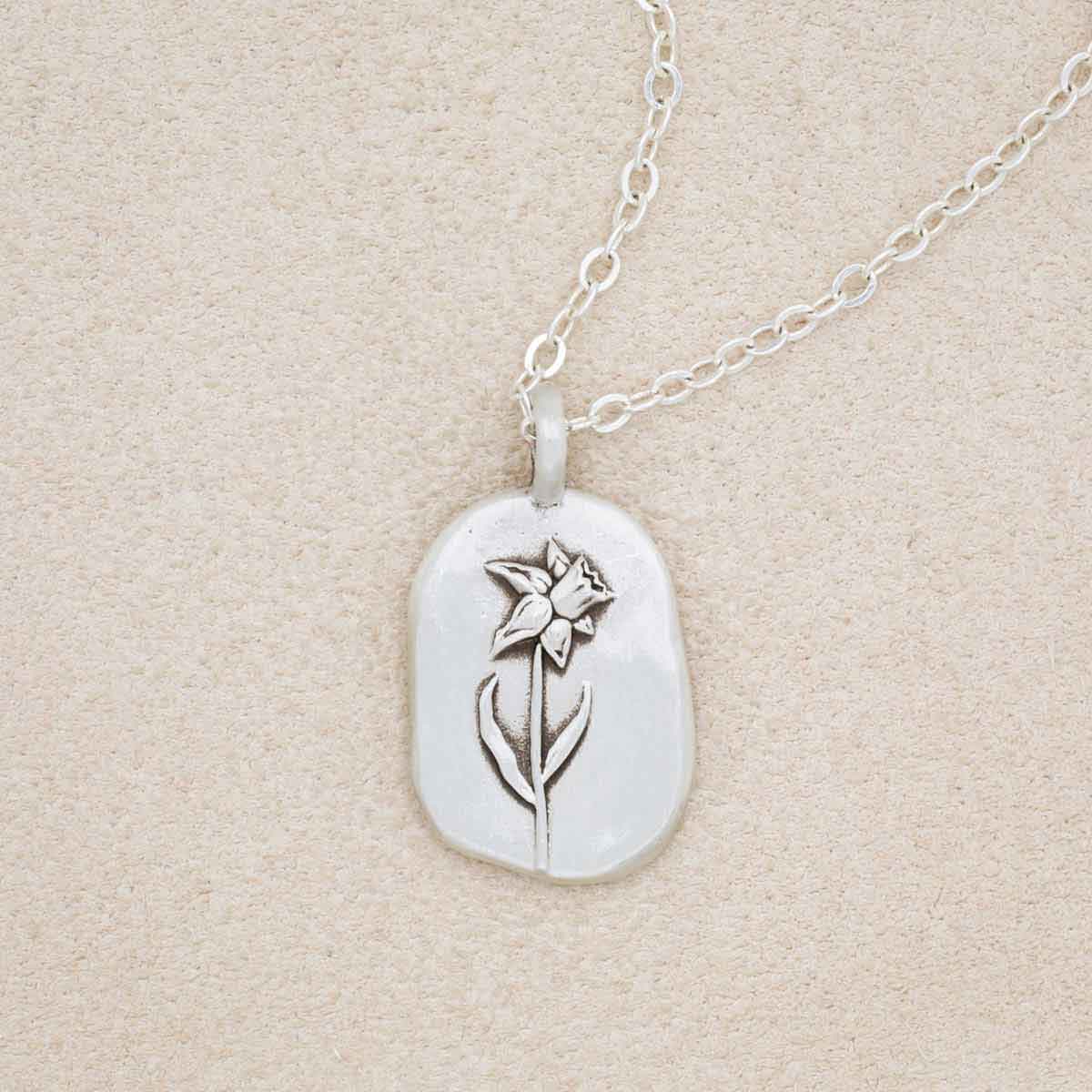 sterling silver March birth flower necklace, on beige background