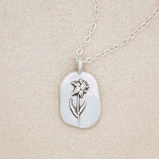 sterling silver March birth flower necklace, on beige background