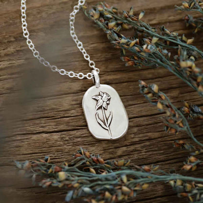 girl holding a sterling silver March birth flower necklace