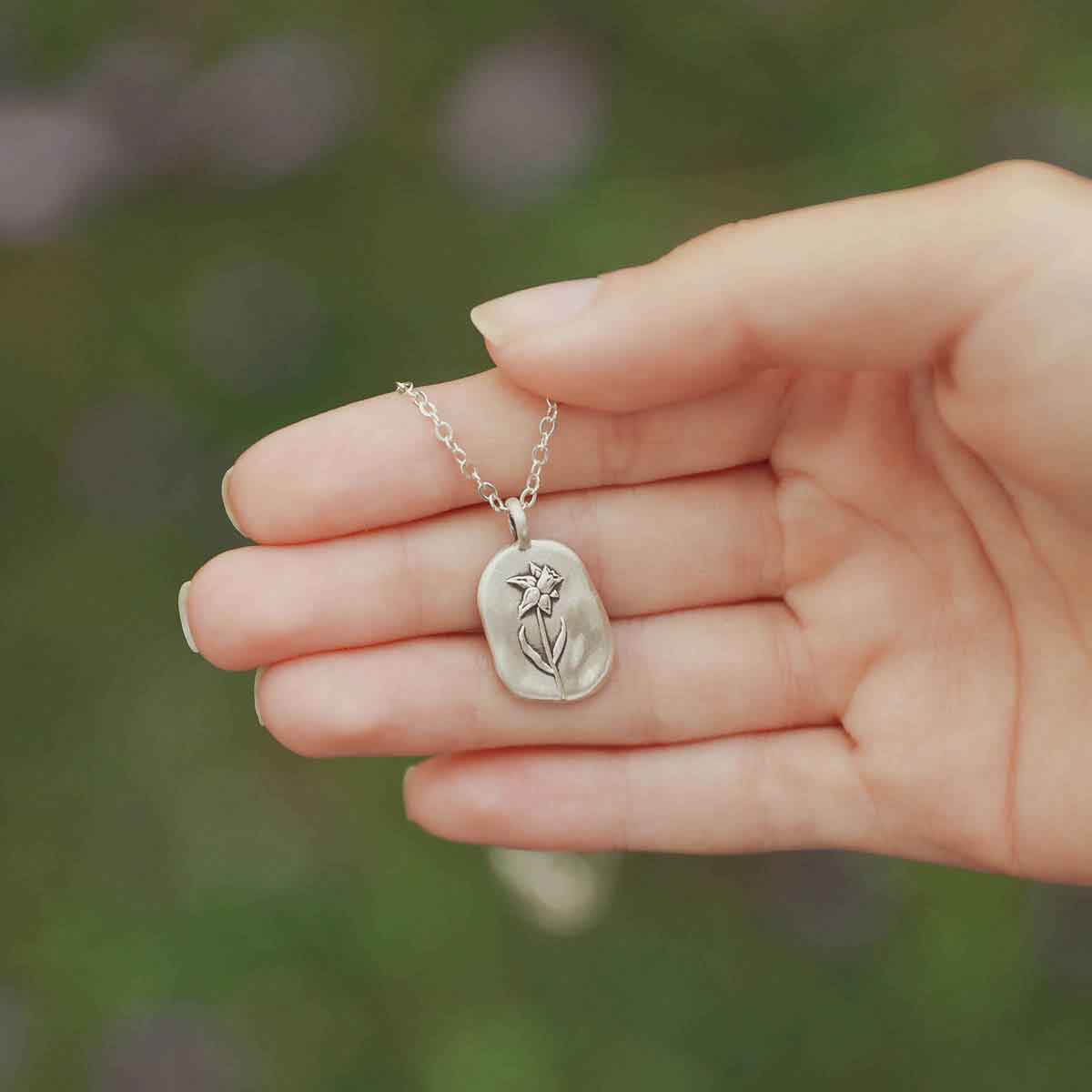 girl wearing a sterling silver March birth flower necklace