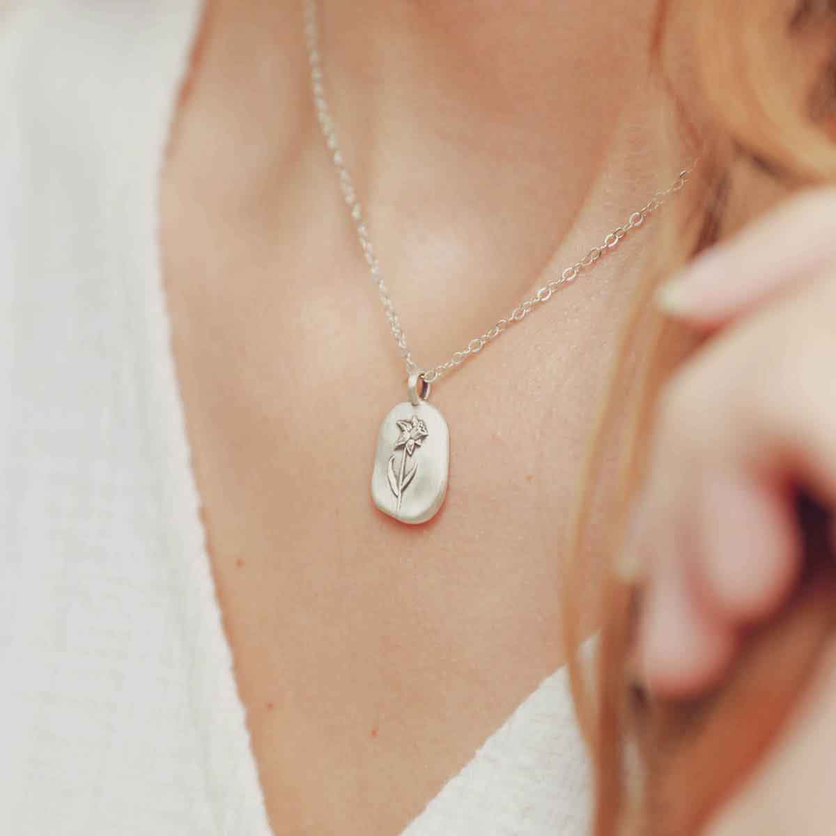 girl wearing a sterling silver March birth flower necklace